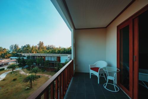a balcony with a table and chairs on it at Nana Beach Hotel & Resort in Pathiu