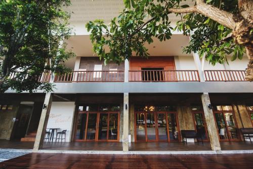 a building with glass doors and trees in front of it at Nana Beach Hotel & Resort in Pathiu