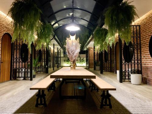 a table in a room with two benches and plants at The Matta in Bangkok