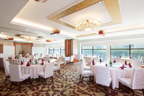 a banquet hall with white tables and white chairs at Jianguo Hotel Shanghai in Shanghai