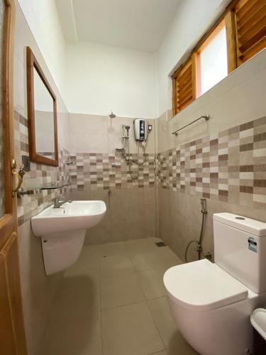 ein Bad mit einem WC und einem Waschbecken in der Unterkunft Aqua Blue in Arugam Bay