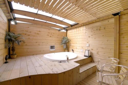 a large bathroom with a tub in a wooden wall at ホテル チャペル クリスマス かつらぎ Adult Only in Katsuragi