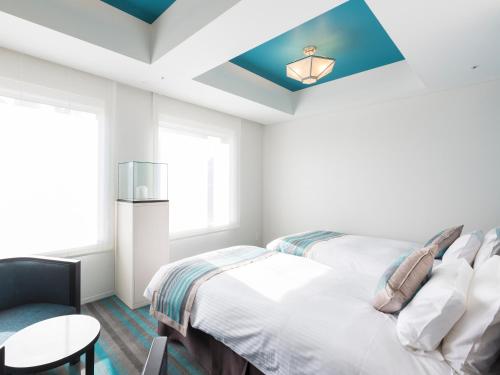 a bedroom with two beds and a blue ceiling at Hotel Dans Le Coeur Osaka Umeda in Osaka