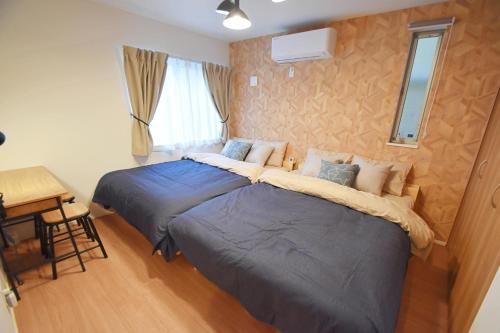 a bedroom with two beds and a desk in it at FINOA Residential Suite Asakusa/Oshiage Skytree in Tokyo