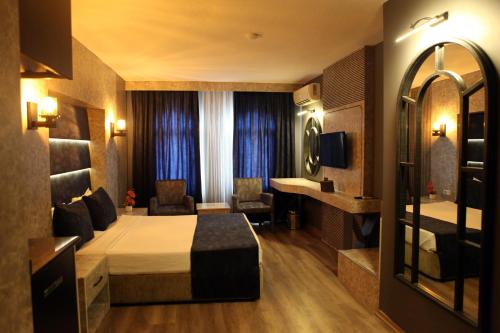 Habitación de hotel con cama y espejo en Aktas Hotel, en Mersin