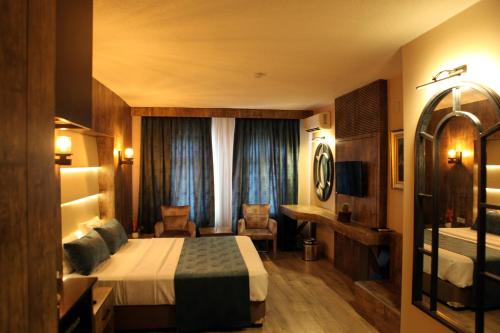 a hotel room with a bed and a desk at Aktas Hotel in Mersin