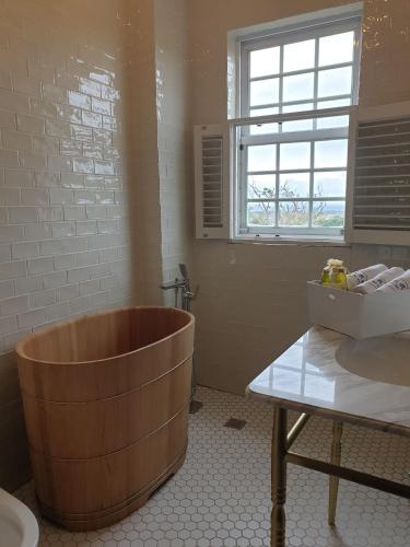 a bathroom with a wooden tub and a sink at 墾丁勿忘我城堡莊園 in Hengchun