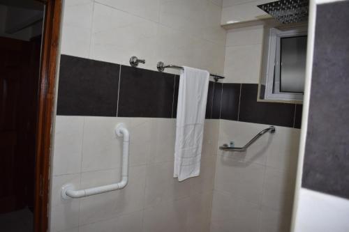 a bathroom with a shower with a white towel at Empolos Hotel Nakuru in Nakuru
