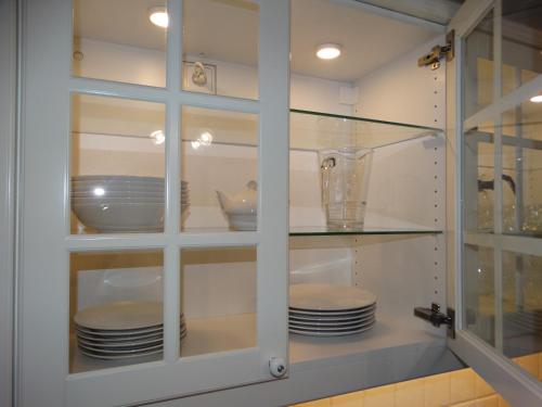 szklana szafka z talerzami i naczyniami w obiekcie Apartamenty Miku w mieście Krynica Zdrój