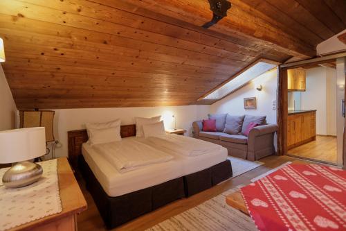 ein Schlafzimmer mit einem Bett und einem Sofa in einem Zimmer in der Unterkunft Appartement Elisabeth in Kitzbühel