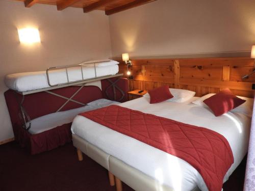 una camera d'albergo con due letti con lenzuola rosse di Hotel Le Clocher a Champoluc