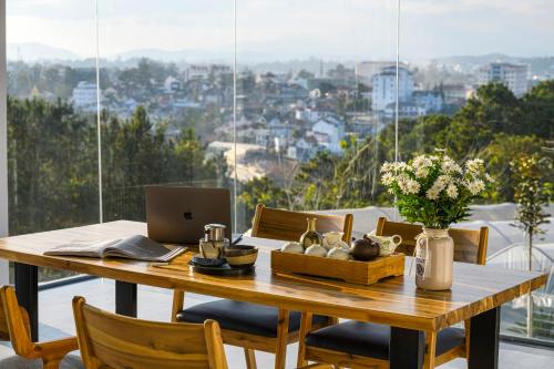 a dining room table with a laptop computer on it at Q&P Smart Ville in Da Lat