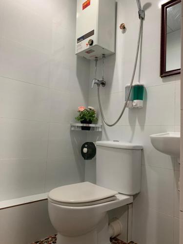 Un baño blanco con inodoro y lavabo. en Sydney Hostel, en Hong Kong