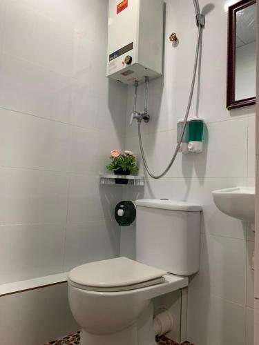 a white bathroom with a toilet and a sink at Sydney Hostel in Hong Kong