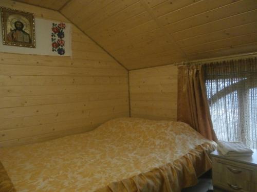 ein Schlafzimmer mit einem Bett in einem Blockhaus in der Unterkunft Karpatskiy Domik Izki in Izky