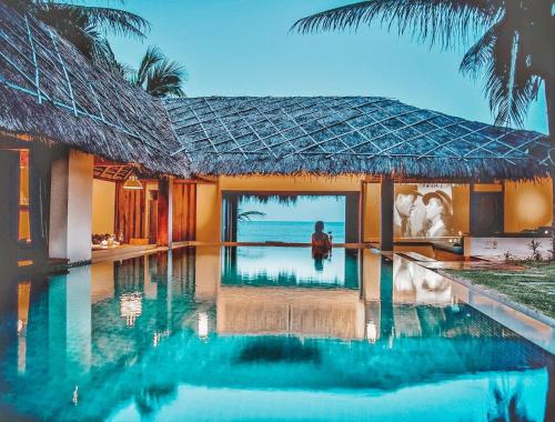 a villa with a swimming pool next to the ocean at Green Organic Villas in Phan Thiet