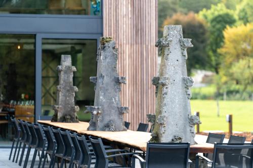 a group of tables and chairs sitting outside of a building at Sous le Bois I in Érezée