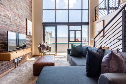 a living room with a couch and a tv at Urban Artisan Luxury Suites by Totalstay in Cape Town