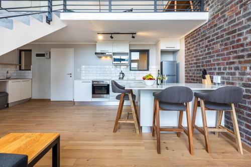 a kitchen with a brick wall and a table and chairs at Urban Artisan Luxury Suites by Totalstay in Cape Town
