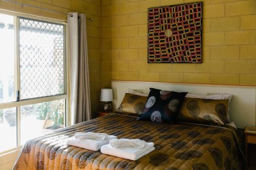 1 dormitorio con 1 cama con toallas en Wallaby Ridge Retreat, en Mount Tamborine
