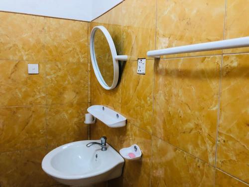 a bathroom with a sink and a mirror on the wall at New Ocean Hill Hotel in Hikkaduwa