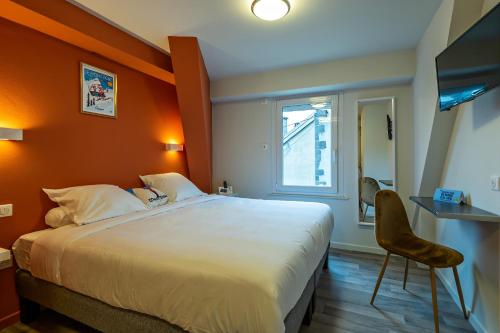 ル・モンドールにあるLogis Hôtel le Regisのベッドルーム1室(オレンジ色の壁の大型ベッド1台付)
