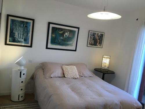 sypialnia z łóżkiem i obrazami na ścianie w obiekcie Maison Fleurie w mieście Uhart-Cize
