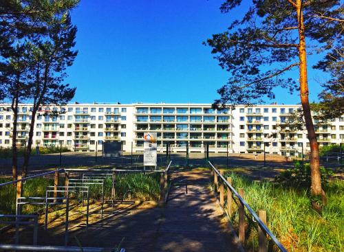a large white building with trees in front of it at Strandresort Prora - WG 202 mit Meerblick und Sauna in Binz