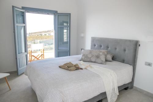 una camera da letto con un letto con una grande finestra di Luxe Maroussi Villas a Pyrgos