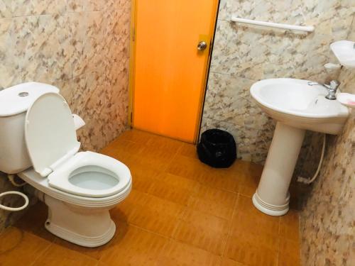 a bathroom with a toilet and a sink at New Ocean Hill Hotel in Hikkaduwa
