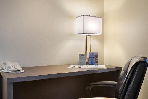 a desk with a phone and a lamp on it at Days Inn by Wyndham Ellensburg in Ellensburg