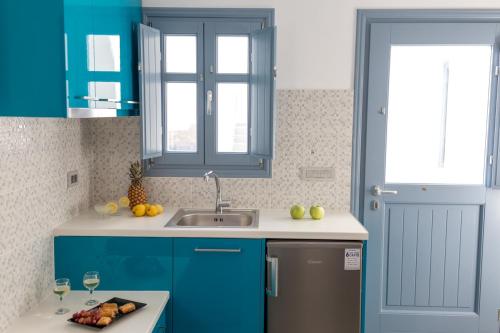 una cucina con mobili blu e un lavandino di Luxe Maroussi Villas a Pyrgos