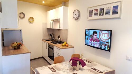 a kitchen with a tv hanging on the wall at Premium Apartments Peschiera in Peschiera del Garda