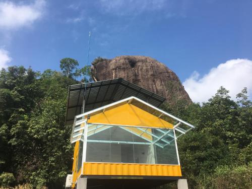 un bâtiment avec une montagne en arrière-plan dans l'établissement Sky Retreat - Sri Lanka, à Gampaha