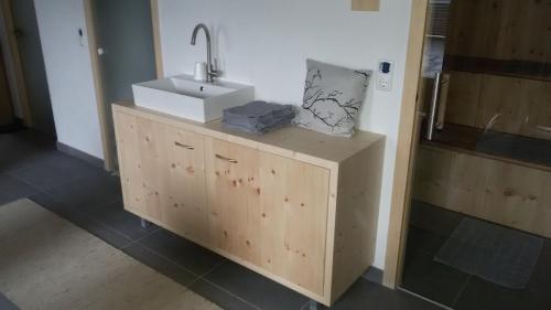 baño con lavabo y armario de madera en Apartment-Bergblick en Aschau