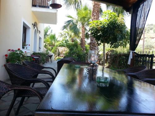 - une table en bois sur une terrasse avec des chaises dans l'établissement Mistral Boutique Hotel, à Méganisi