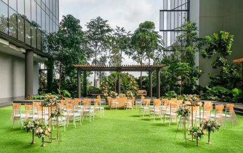 a set up for a wedding in a building with tables and chairs at Oasia Hotel Downtown, Singapore by Far East Hospitality in Singapore