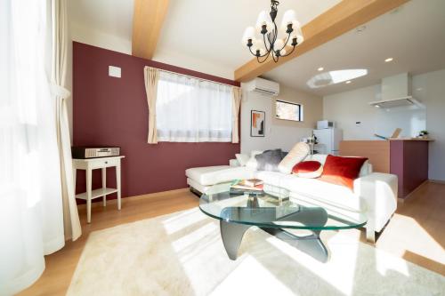 a living room with a white couch and a glass table at Villa Fuji Bon Voyage Sora in Fujikawaguchiko