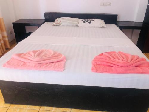 a bed with two pink towels on top of it at New Ocean Hill Hotel in Hikkaduwa