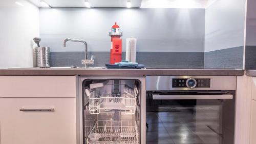 a kitchen with a dishwasher and a sink with a dish rack at Seehüsli near Interlaken, Grindelwald and Lauterbrunnen in Därligen