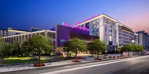 budynek z fioletowym znakiem na boku w obiekcie Crowne Plaza Wuzhen, an IHG Hotel w mieście Tongxiang