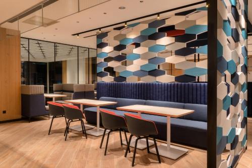 a restaurant with tables and chairs and a colorful wall at Holiday Inn Express Chiayi by IHG in Chiayi City