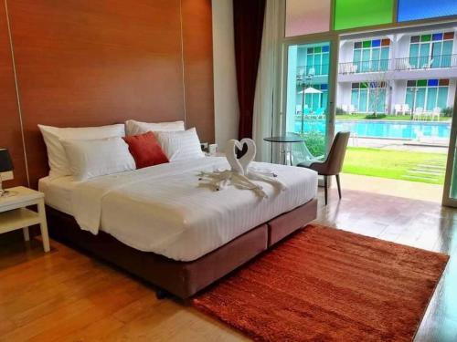 a bedroom with a large bed with a large window at Southern Airport Hotel Hatyai in Hat Yai