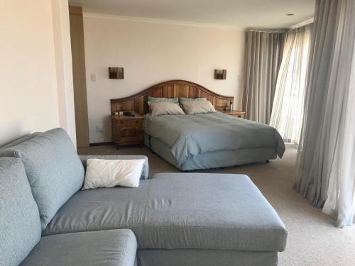 ein Wohnzimmer mit einem Bett und einem Sofa in der Unterkunft Villa Litori in Glentana