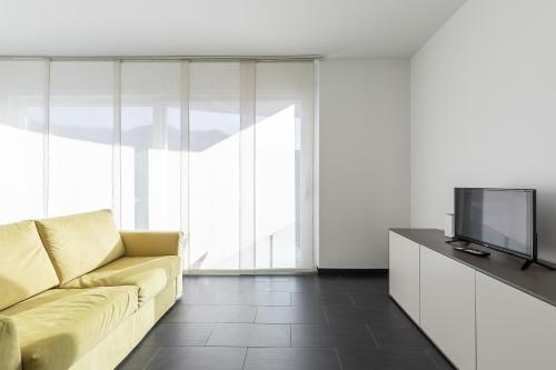 a living room with a couch and a tv at Roggia Apartments by Quokka 360 - central flats with parking space in Lugano