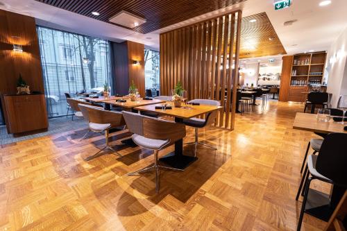 a restaurant with wooden floors and tables and chairs at Hestia Hotel Kentmanni in Tallinn