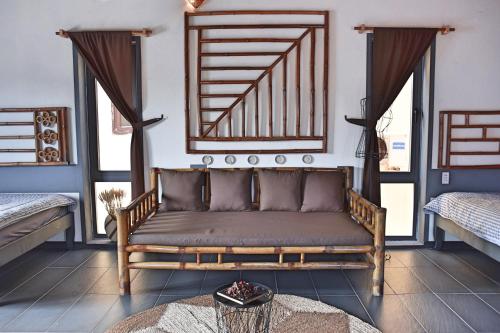 a living room with a couch and two windows at The Happy Bird B&B in Hoi An