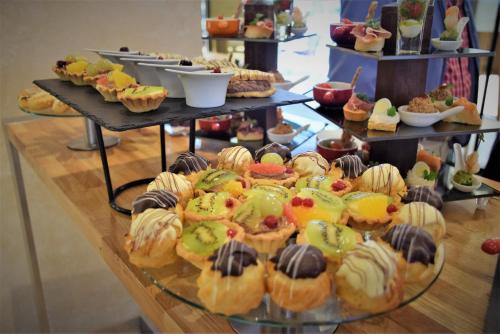 a display of various pastries and desserts on a table at Mercure Bucharest Unirii in Bucharest