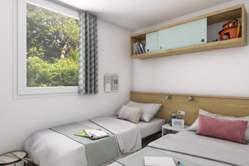 a room with two beds and a couch and a window at Camping Torre Castiglione in Torre Lapillo