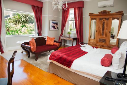 een slaapkamer met een groot bed en een stoel bij Abbey Manor Luxury Guesthouse in Kaapstad